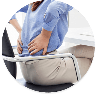 person sitting in chair holding lower back