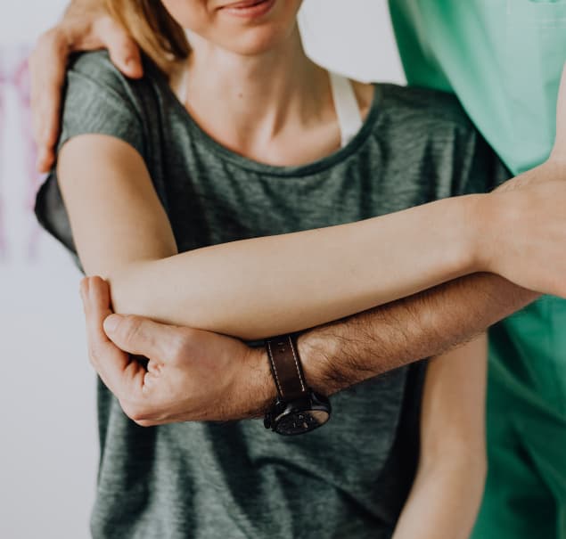 physical therapist adjusting patient shoulder