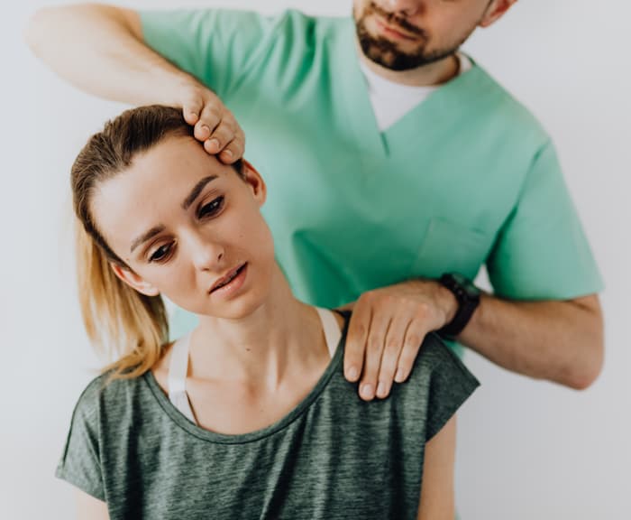 physical therapist adjusting patients neck