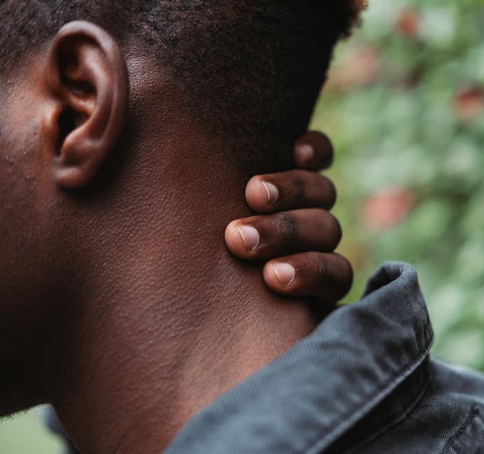 man holding neck
