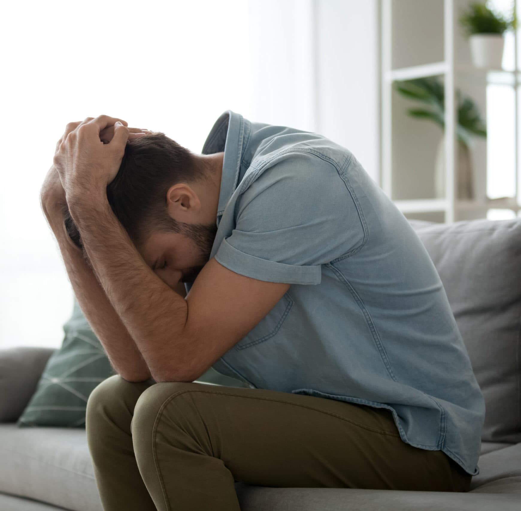 a man holding his head in his arms