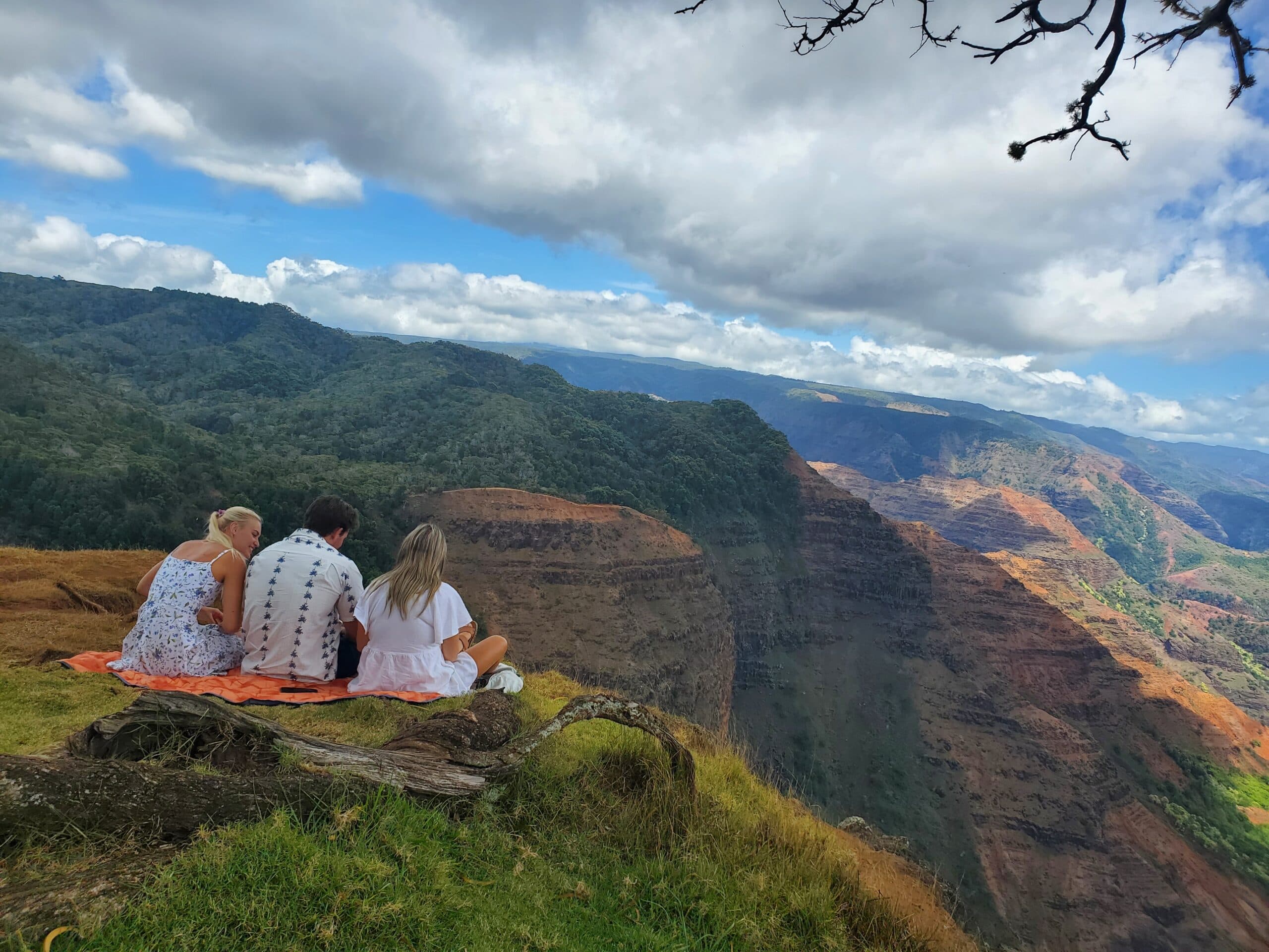 a group sitting on the edge of a cliff